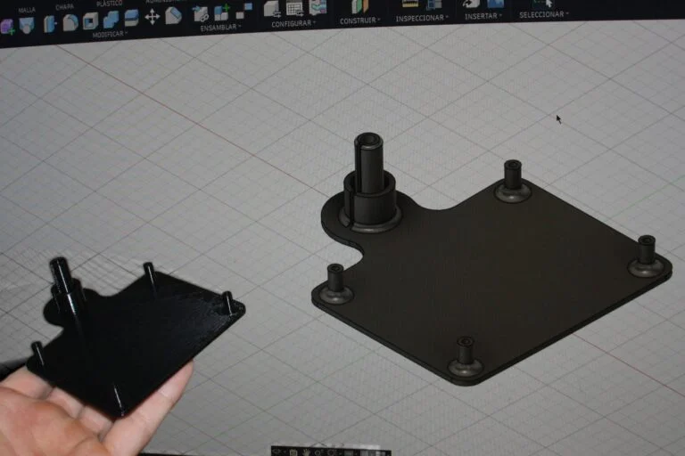 Una mano sostiene una bandeja negra impresa en 3D delante de la pantalla con su modelo