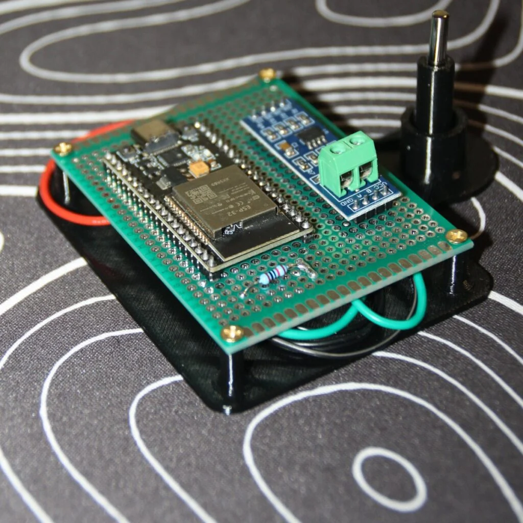 La bandeja negra impresa en 3D con la placa del ESP32, el módulo RS485 y la sonda montados encima